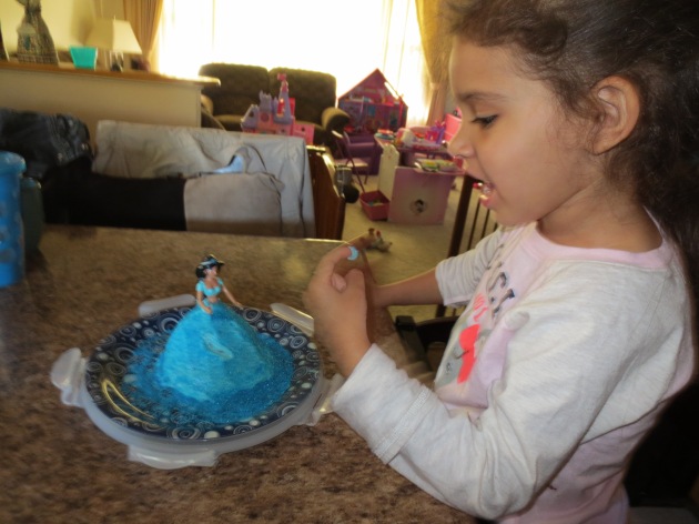 Tasting the blue frosting with blue sparkles.  She loved it.