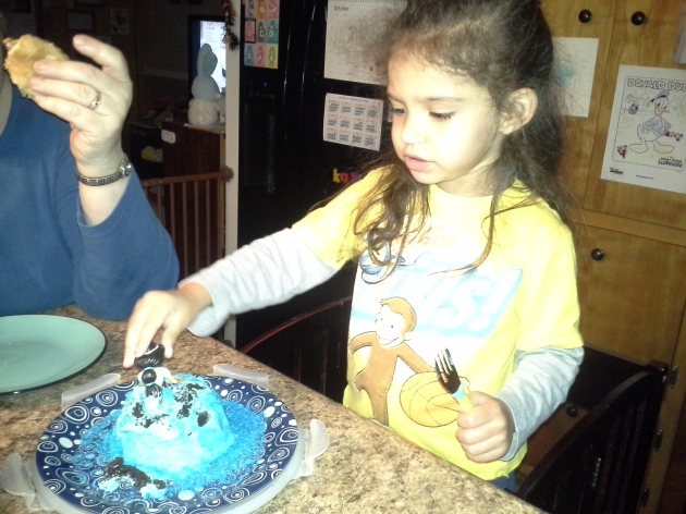 Trying to get her Jasmine figurine out of the cake.